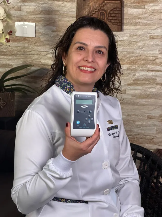 Rosane mostrando o aparelho de estimulação usado nas sessões